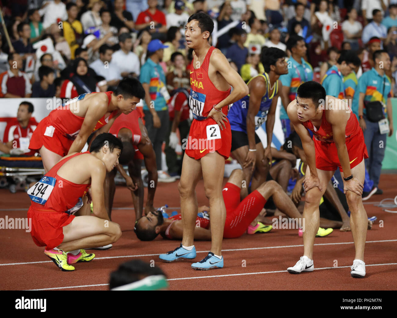 (180830) -- di Jakarta, il 30 agosto 2018 (Xinhua) -- atleti di Cina reagire dopo uomini 4x400m relè di atletica al XVIII Giochi Asiatici in Jakarta, Indonesia su agosto 30, 2018. (Xinhua/Wang Lili) Foto Stock