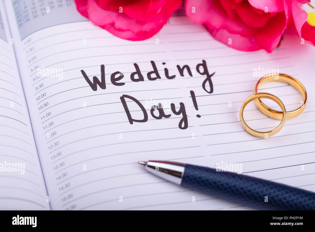 Due anelli d'oro e penna sul diario con il giorno del matrimonio il testo  Foto stock - Alamy