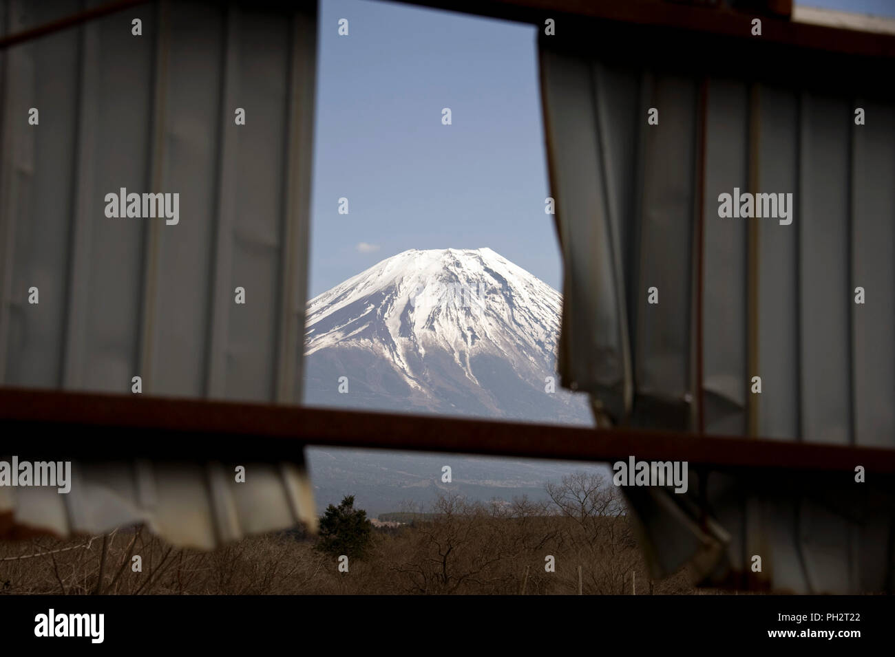 Mt Fuji può essere visto attraverso un edificio abbandonato durante una passeggiata lungo il Plateau Asagiri nella Prefettura di Shizuoka Giappone il 22 marzo 2013. Giappone iconici Foto Stock