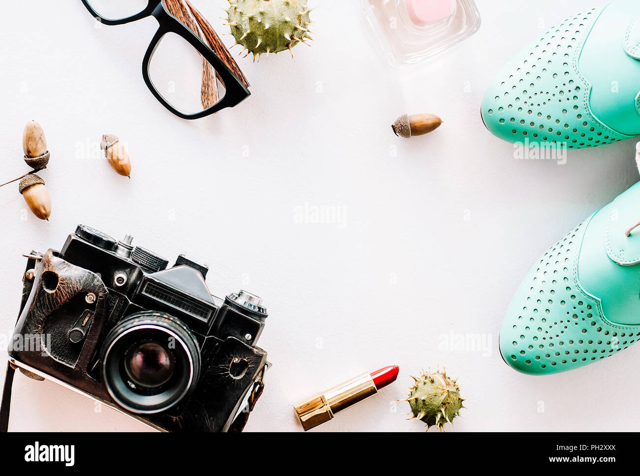 La moda delle calzature in pelle giacciono con la telecamera, bicchieri e ghiande. Foto Stock