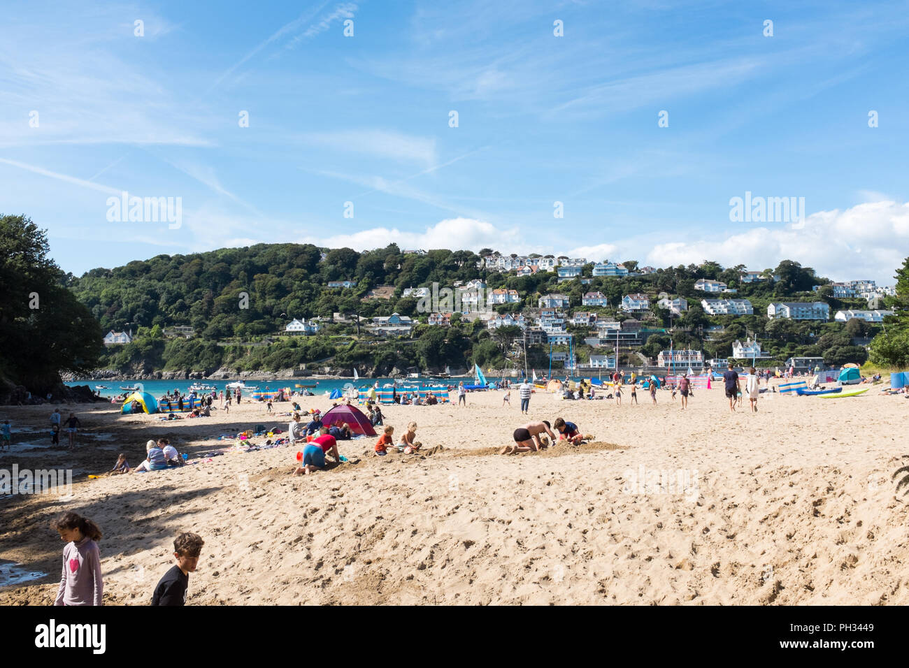 Visitatori godendo della tarda estate sole su una spiaggia a Salcombe estuario vicino Oriente Portlemouth nel sud prosciutti, Devon Foto Stock