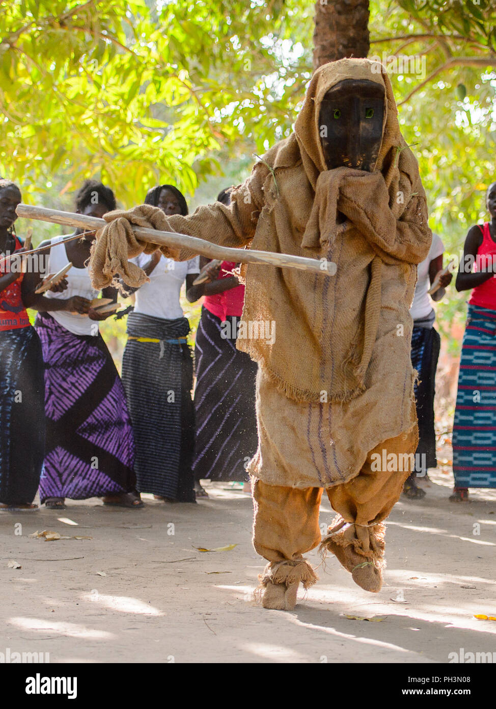 Kaguit vil., SENEGAL - Apr 30, 2017: Unidentified Diola uomo in costume e  maschera tiene un bastone di legno durante una danza tradizionale Kumpo in  un sacro in avanti Foto stock - Alamy