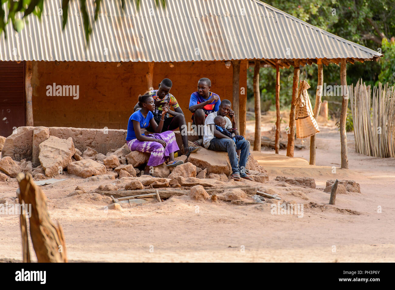 OUSSOUYE, SENEGAL - Apr 30, 2017: Unidentified senegalesi Sedersi sulle rocce vicino alla costruzione nel bosco sacro vicino villaggio Kaguit Foto Stock