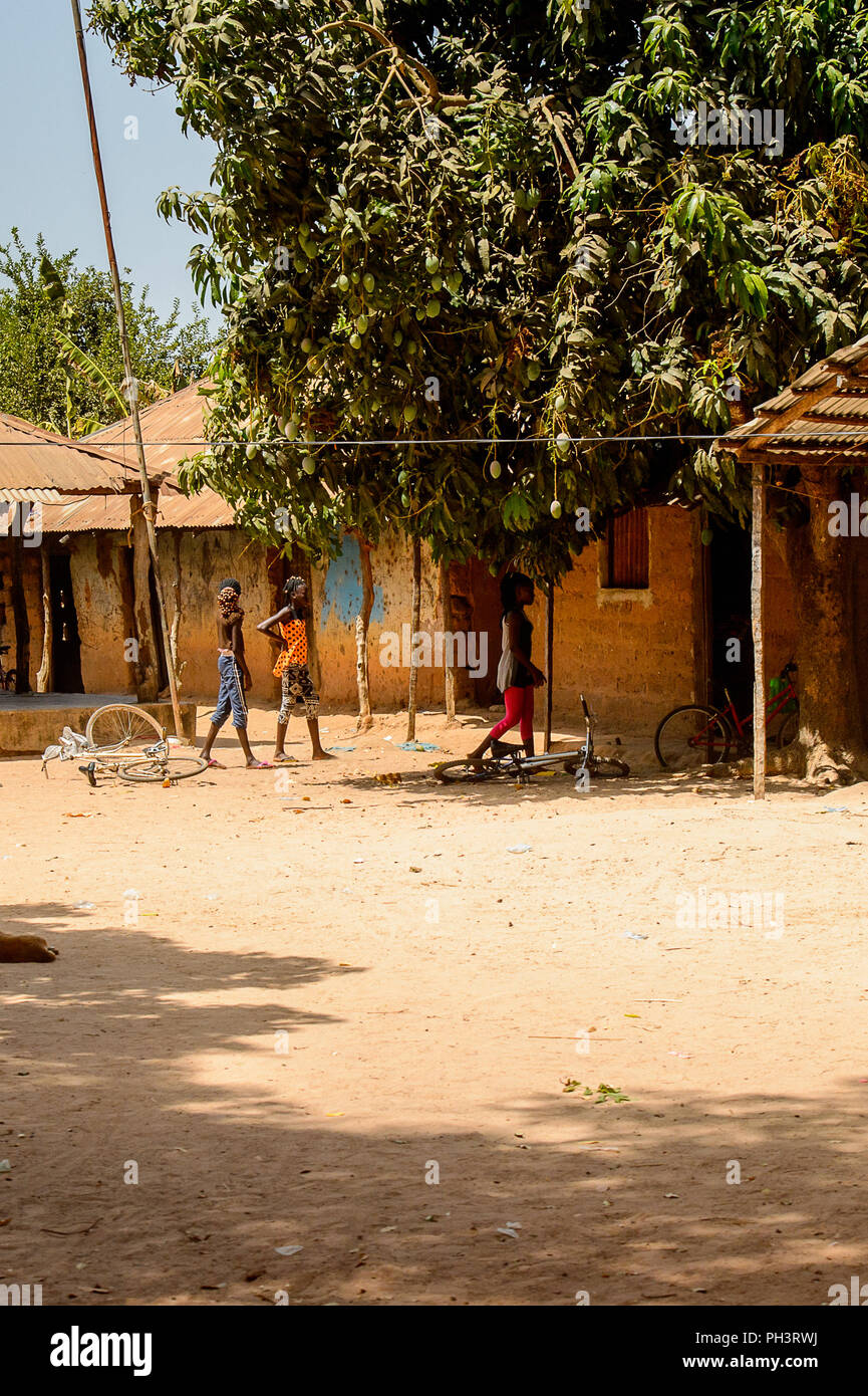 Strada di BISSAU GUINEA B. - 1 Maggio 2017: Unidentified donne locali con trecce appendere fuori nel cortile in un villaggio in Guinea Bissau. Ancora molte persone in Foto Stock