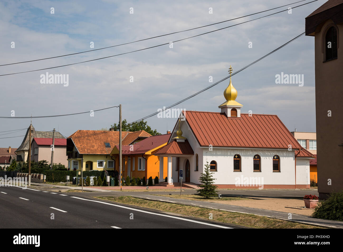 La Slovenské Nové Mesto, Slovacchia. 24 Agosto, 2018. Una chiesa moderna e le case di un villaggio sul lato slovacco di confine con l'Ungheria. Foto Stock