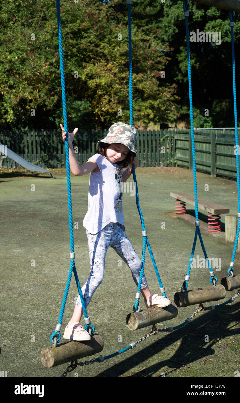 6 anno vecchia ragazza in un parco giochi Foto Stock