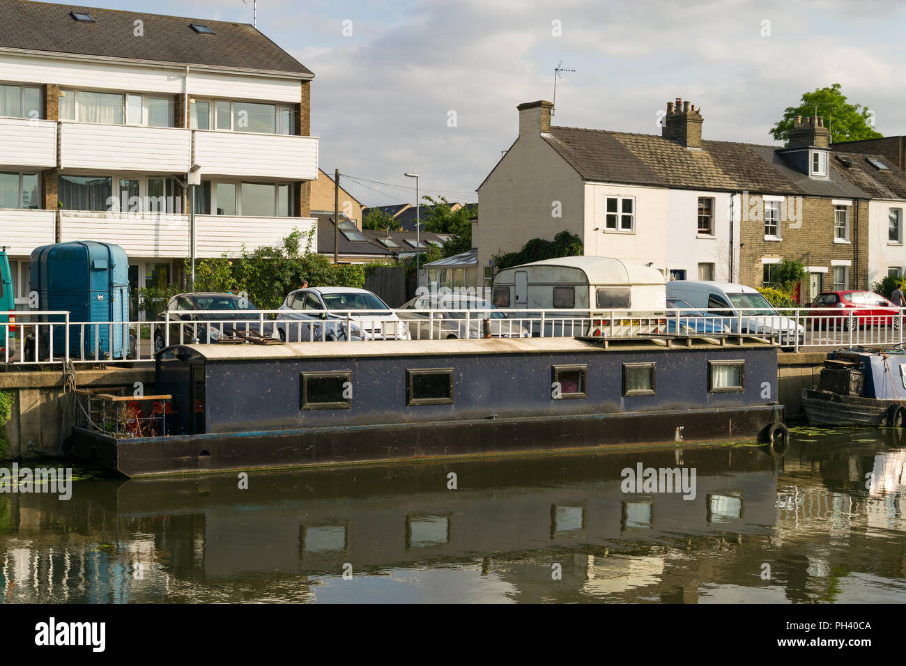 Un narrowboat o stretta barca ormeggiata lungo il fiume Cam, utilizzato come a lungo termine alloggiamento alternativi, Cambridge, Regno Unito Foto Stock