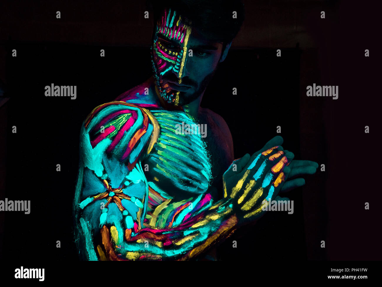 Giovane uomo dipinta in vernice fluorescente Foto Stock