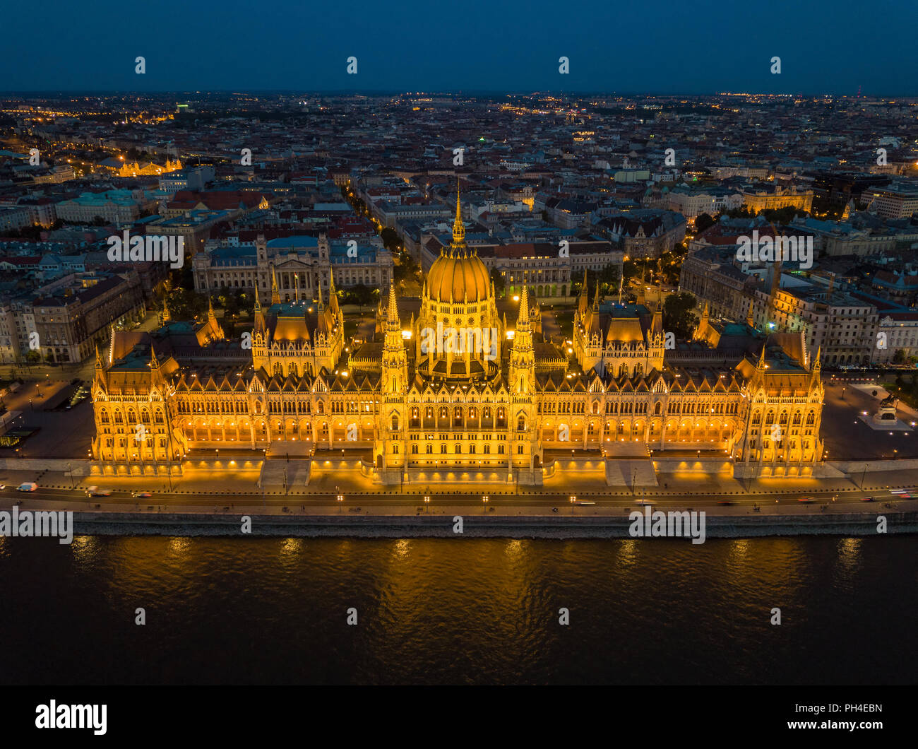 Budapest, Ungheria - vista aerea del bellissimo Parlamento illuminato di Ungheria (Orszaghaz) al blue ora con skyline Inumero di Budapest a sfondo Foto Stock