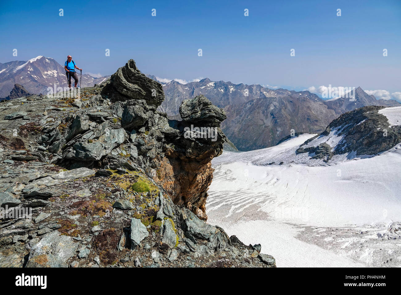 Femmina solitario escursionista sopra Saas Fee, a Mittelallalin comprensorio sciistico estivo, Saastal, Svizzera Foto Stock