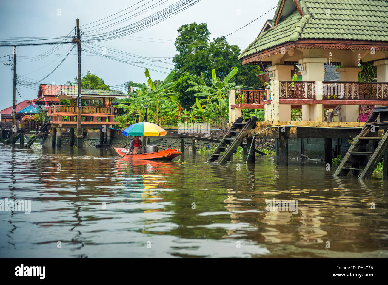 Vecchia donna vende cibo dalla sua barca nei canali di Nonthaburi Foto Stock