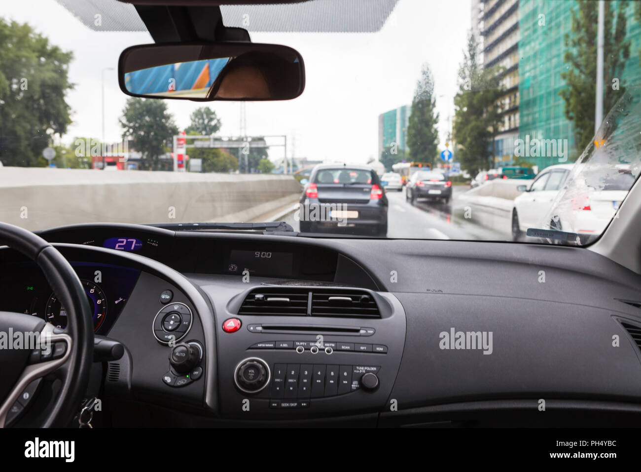 Alla guida di una autovettura in un ingorgo, vista dall'interno sulla strada affollata Foto Stock