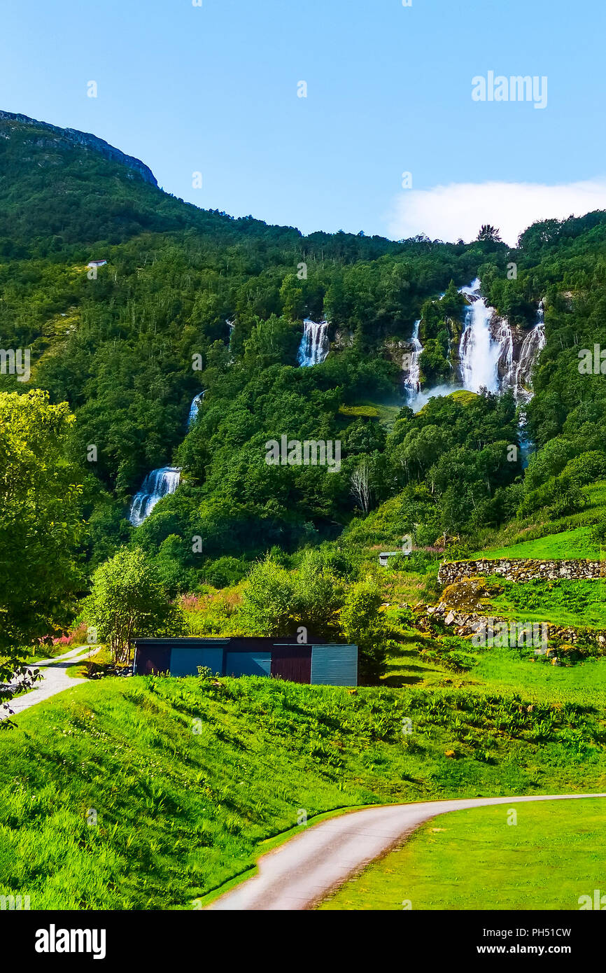 Cascata norvegese paesaggio di montagna vicino a Nordfjord e casa rurale Foto Stock