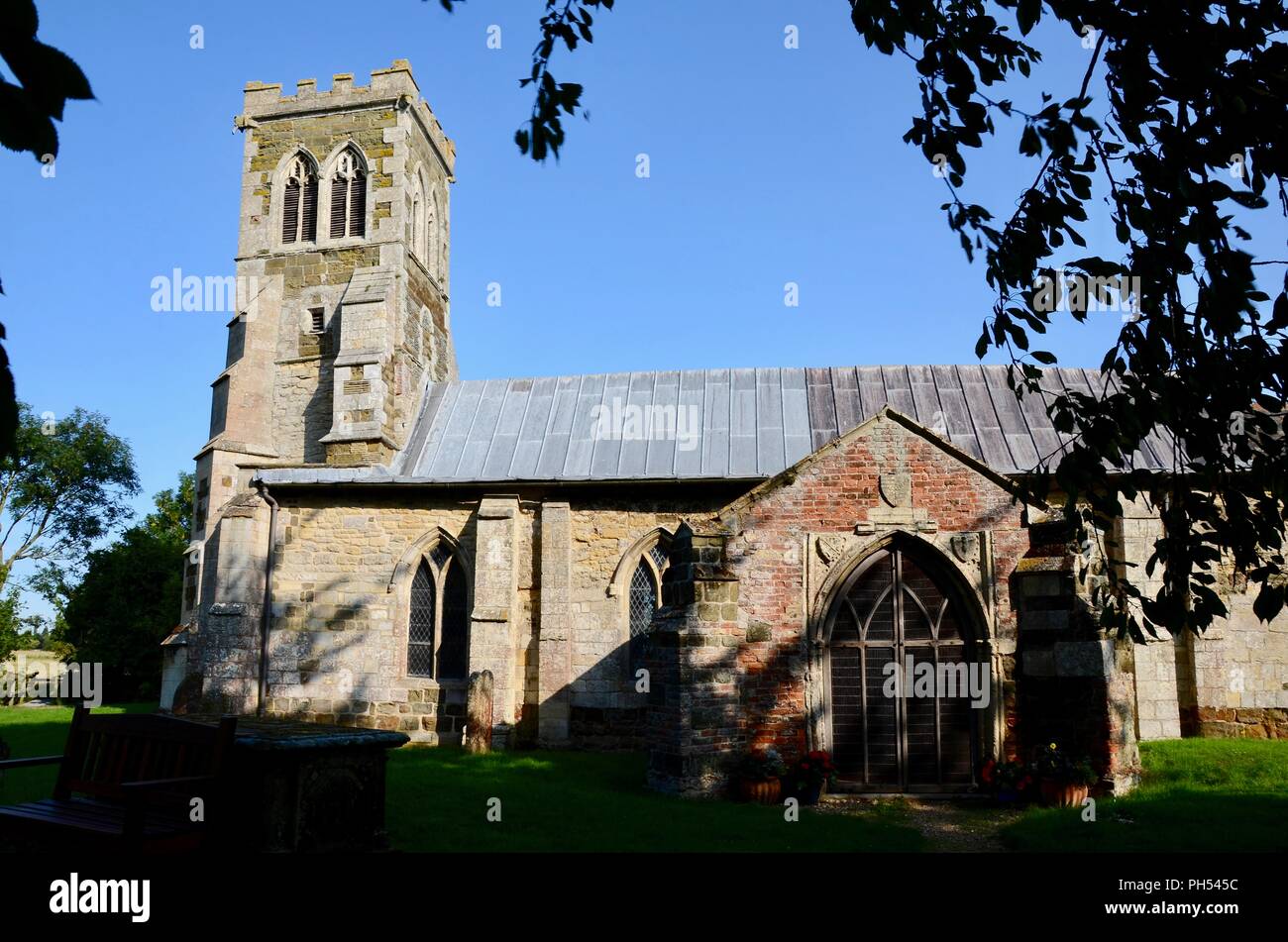 Esterno di tutti i santi " Chiesa, Saltfleetby, Lincolnshire ,UK,mostra la torre pendente con butresses. Foto Stock