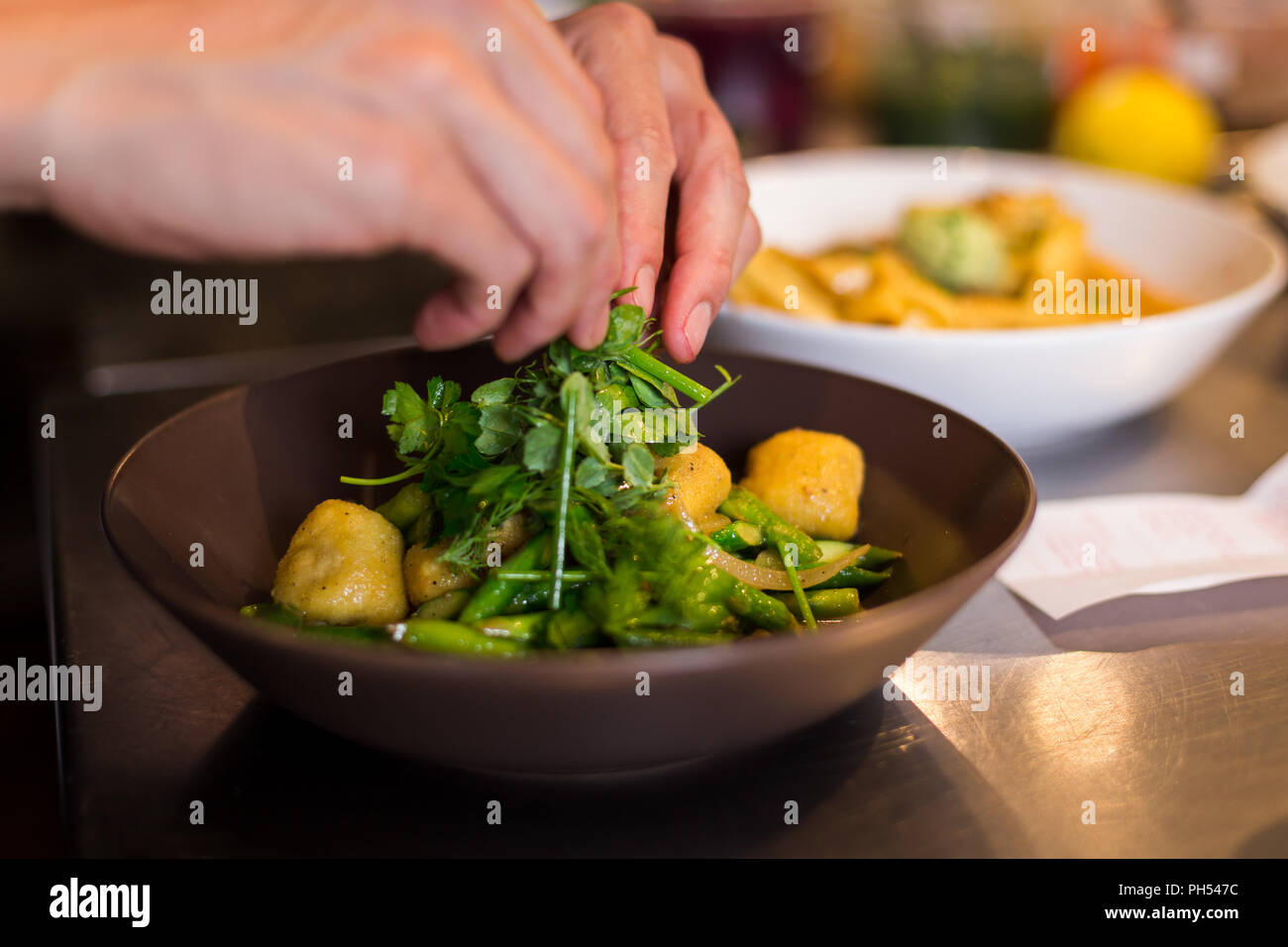 Chef di placcatura di ricotta fresca gli gnocchi in un ristorante italiano. Foto Stock