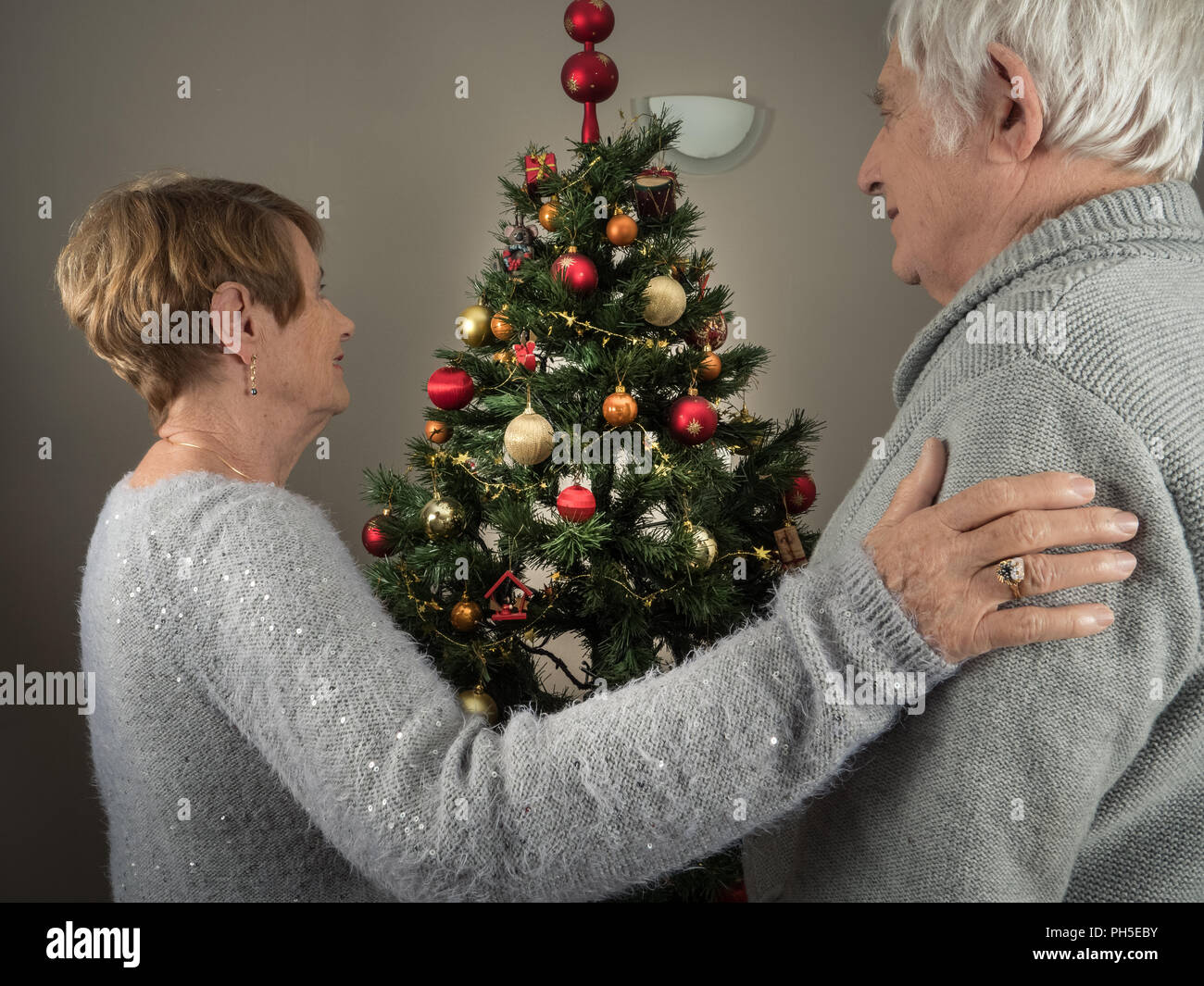 Ritratto orizzontale di una coppia di anziani la visione di un albero di Natale a casa Foto Stock