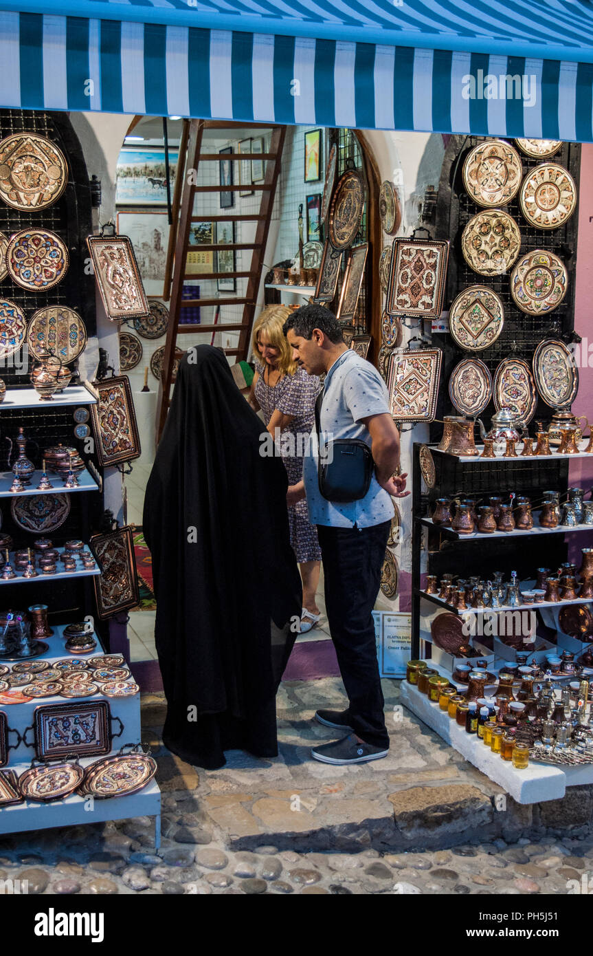 Bosnia: una donna musulmana velata con suo marito in uno dei negozi del Vecchio Bazar Kujundziluk, il quartiere musulmano della città vecchia di Mostar Foto Stock