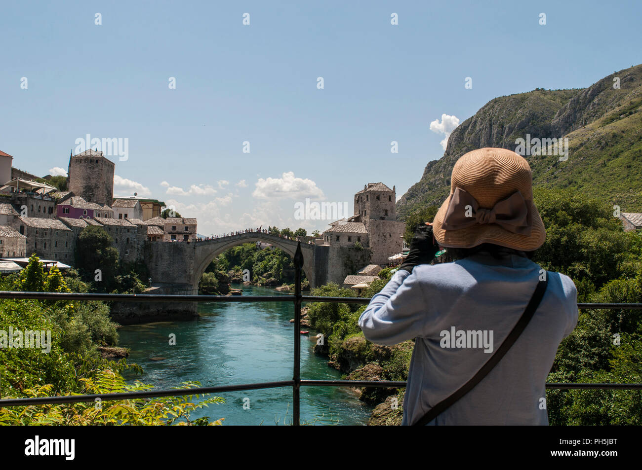 Mostar Bosnia: un turista a scattare foto di Stari Most (Ponte Vecchio), il cinquecentesco Ponte Ottomano, simbolo della città di Mostar, distrutto nel 1993 Foto Stock