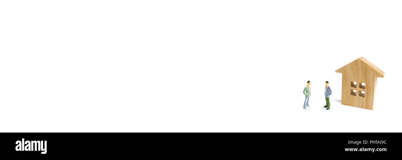 Due uomini sono in piedi accanto a una casa in legno su uno sfondo bianco. Il concetto di discutere i termini della transazione e i dettagli del contratto Foto Stock