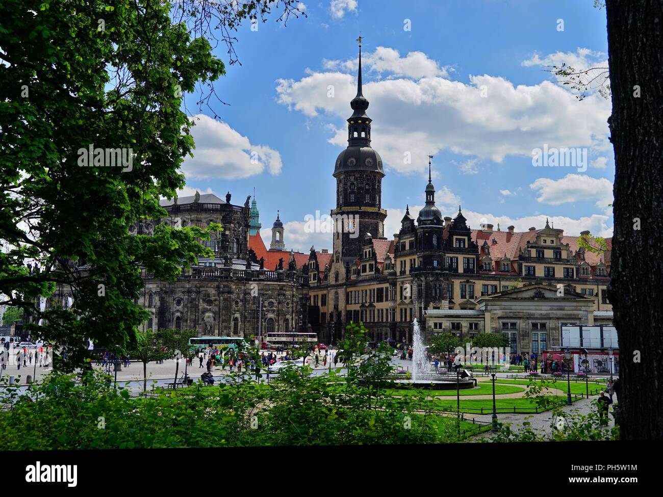 Vista della città vecchia di Dresda con cielo blu e nuvole, albero e fogliame in primo piano Foto Stock