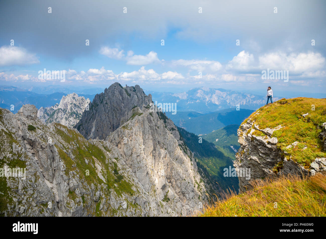 Giovane donna sulla scogliera in sella Mangart, Slovenia Foto Stock