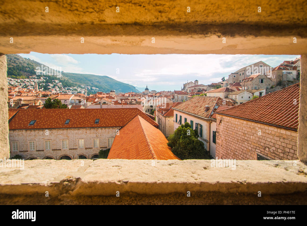 I tetti e le chiese della città vecchia di Dubrovnik, Croazia, vista attraverso le pareti di pietra Foto Stock