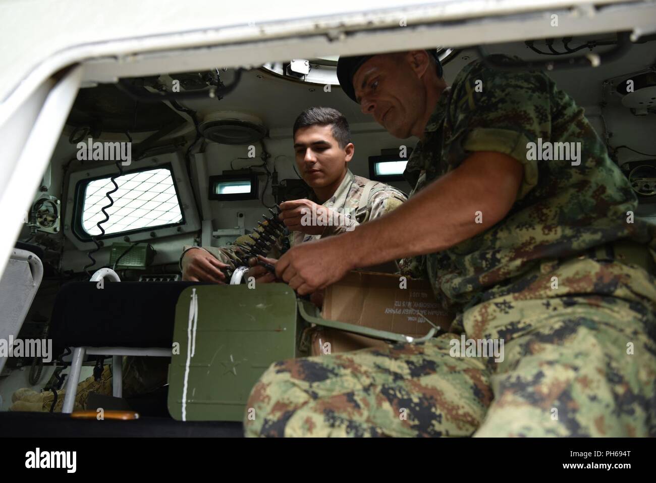 Sotto la guida di un serbo Forze Armate soldato (destra), SPC. Harrison Daniel dell'Ohio National Guard 838th della Polizia Militare azienda impara il corretto corazzato trasporto di personale gunner tattiche durante un campo evento di formazione, Giugno 19, 2018 come parte di esercizio Platinum Wolf. Circa 50 membri del gruppo hanno partecipato a due settimane di pace multinazionale esercizio che ha portato il 10 unite assieme per migliorare la cooperazione militare e l'interoperabilità in Serbia meridionale e Base Borovac Area Formazione, Giugno 11-22. (Ohio National Guard Foto Stock