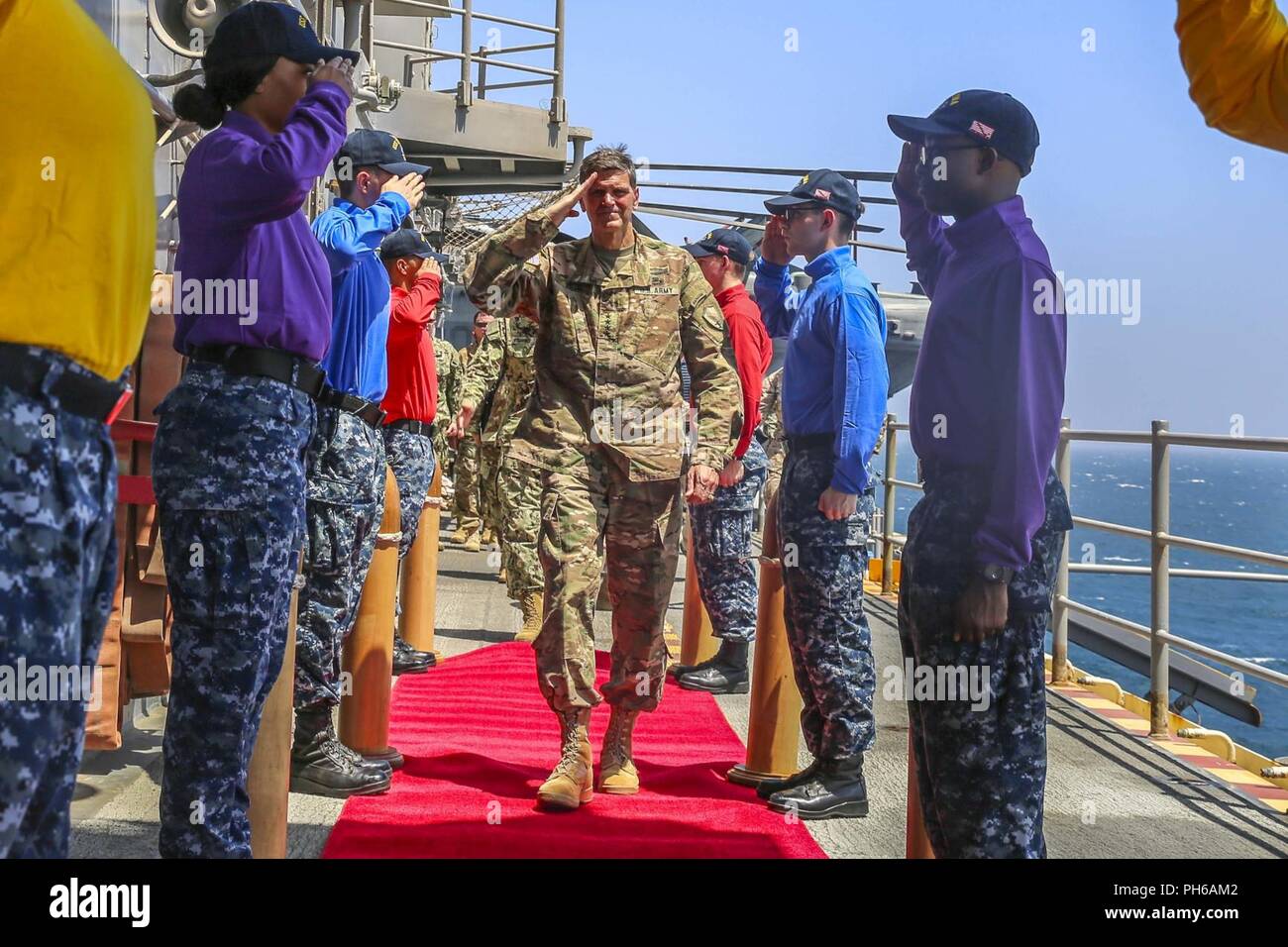 Golfo Arabico (22 giugno 2018) DEGLI STATI UNITI Esercito gen. Giuseppe Votel, commander, U.S. Comando centrale, saluta i marinai come egli viene accolto a bordo del Wasp-classe assalto anfibio nave USS Iwo Jima (LHD 7), 22 giugno 2018. Votel, Vice Adm. Scott Stearney, commander, U.S. Forze Navali del comando centrale e di altri illustri visitatori hanno preso un tour di Iwo Jima e parlato con i membri dell'equipaggio e Marines con la ventiseiesima Marine Expeditionary Unit, che sono attualmente dispiegati per gli Stati Uniti Quinta Flotta di azioni di sostegno le operazioni di sicurezza marittima per rassicurare gli alleati e partner e preservare la libertà di navigati Foto Stock