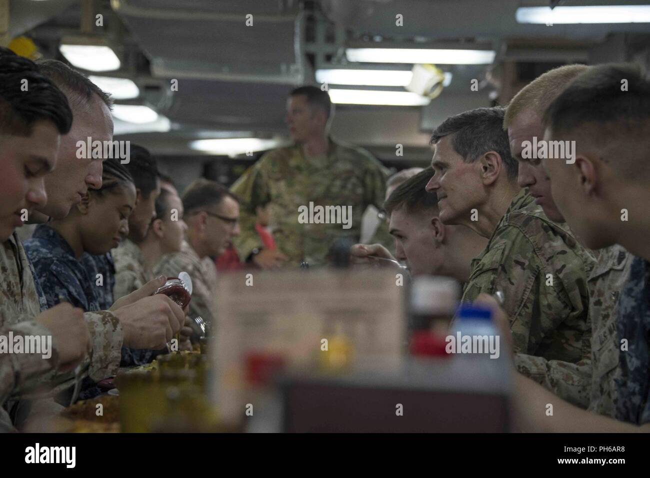 Golfo Arabico (22 giugno 2018) DEGLI STATI UNITI Esercito gen. Giuseppe Votel, comandante della U.S. Comando centrale, Décines con marinai e marines sul disordine dei ponti durante un tour di wasp-classe assalto anfibio nave USS Iwo Jima (LHD 7). Iwo Jima, homeported a Mayport Fla., è sulla distribuzione per gli Stati Uniti Quinta Flotta area di operazioni a sostegno della sicurezza marittima operazioni per rassicurare gli alleati e partner e preservare la libertà di navigazione e il libero flusso di commercio nella regione. Foto Stock