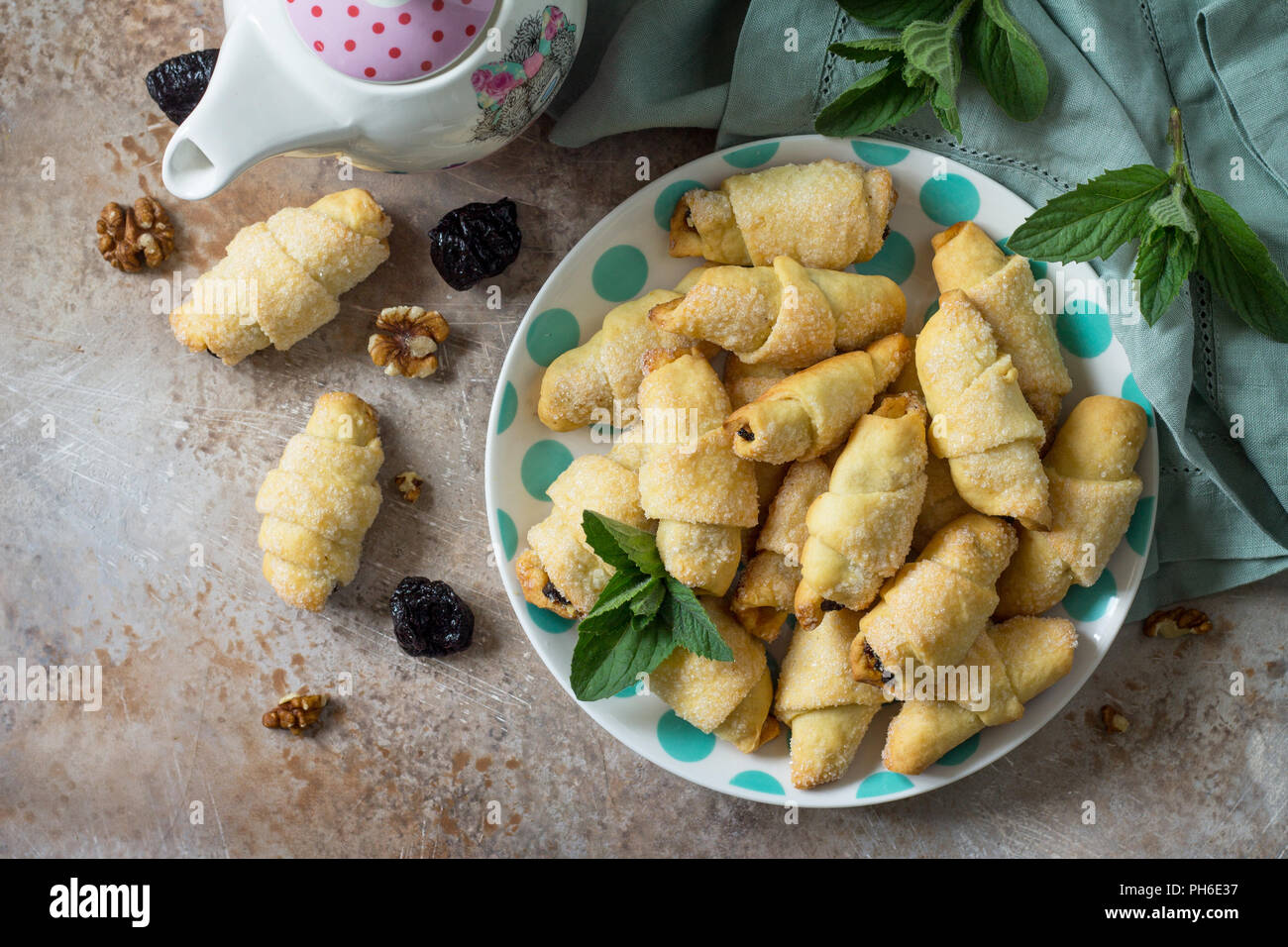 Biscotti fatti in casa con le prugne secche e noci su una piastra su un tavolo, bagels. Vista superiore piatta sullo sfondo dei laici. Foto Stock