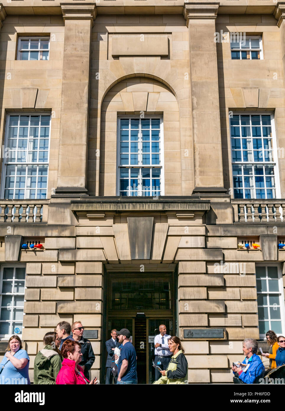 Parte anteriore del Edinburgh Alta Corte di Justiciary, Royal Mile di Edimburgo, Scozia, Regno Unito durante il festival con la gente camminare passato e le guardie di sicurezza Foto Stock