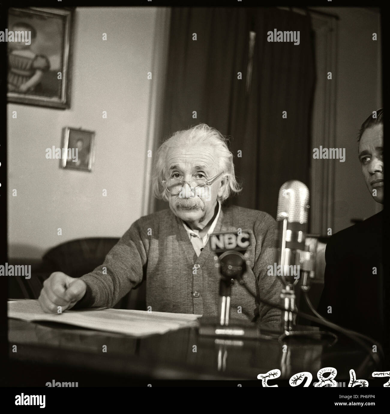 Fisico Albert Einstein seduto a un microfono di NBC. Questa foto è stata scattata durante il 1950 premiere di Eleanor Roosevelt settimanale del programma TV. Albert Einstein avverte che lo sviluppo della bomba a idrogeno porta la possibilità di porre fine alla vita sulla Terra, "entro la gamma di possibilità tecniche". Foto Stock
