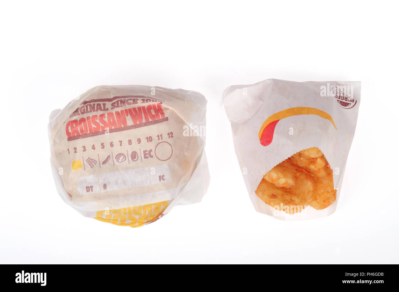 Burger King salsiccia, uova e formaggio Croissan"quale e un hash browns negli involucri su sfondo bianco Foto Stock