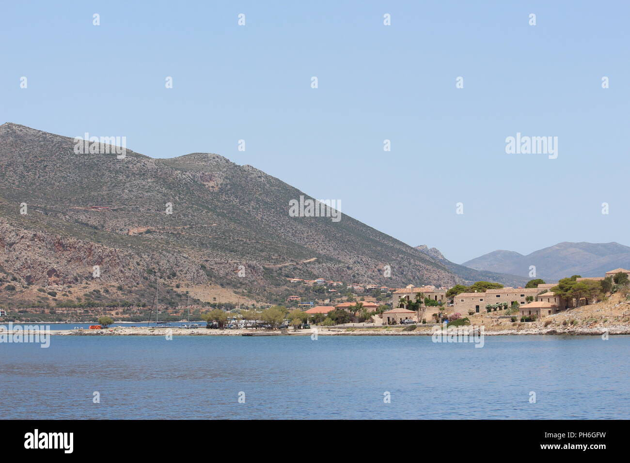 Linea del litorale di Monemvasia Grecia mostra scogliere lungo il mare e le montagne in distanza Foto Stock