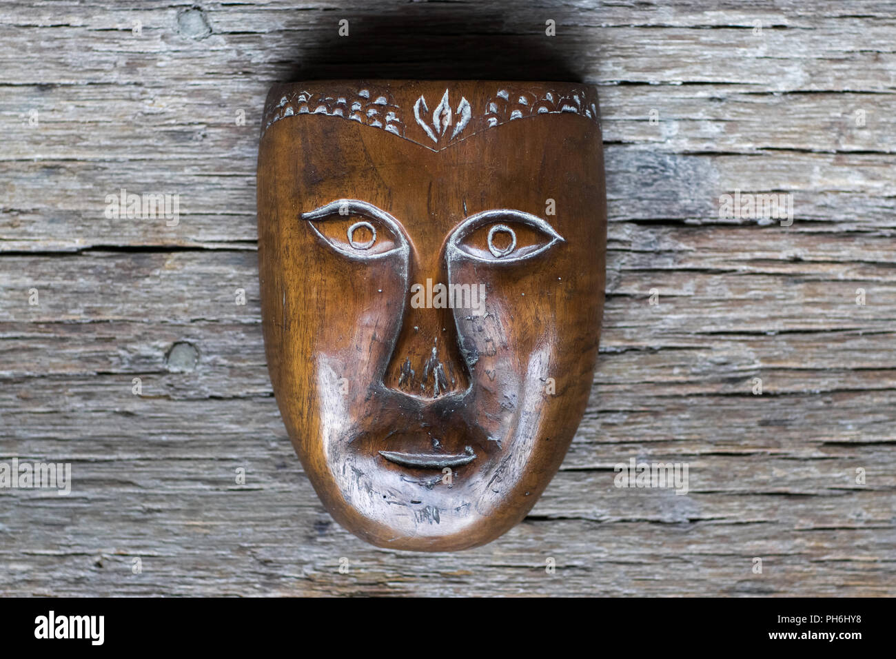 Vecchia in legno fatti a mano maschera sullo sfondo di texture Foto Stock