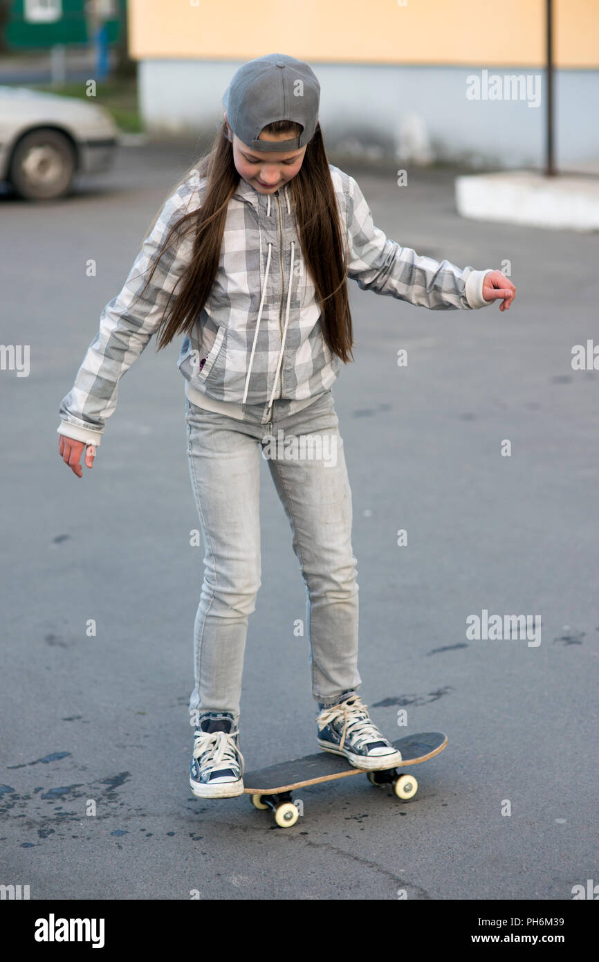 Bambino ragazza all'aperto lo studio skateboard trucchi Foto Stock