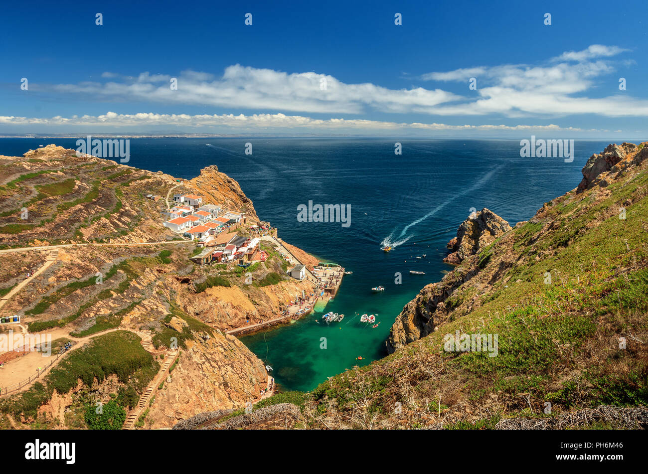 Pescatore di quartiere e il molo d'imbarco sull isola di Berlenga visto dal percorso al faro, con Peniche a vista in una giornata di sole dell'estate. Foto Stock