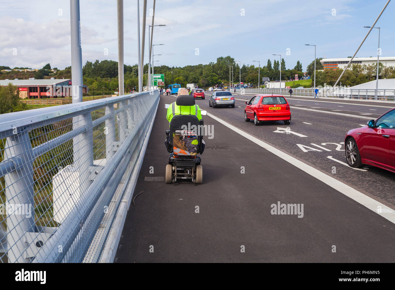 Un uomo su una mobilità scooter e auto utilizzando la cuspide settentrionale ponte che attraversa il fiume indossare a Sunderland,l'Inghilterra,UK Foto Stock