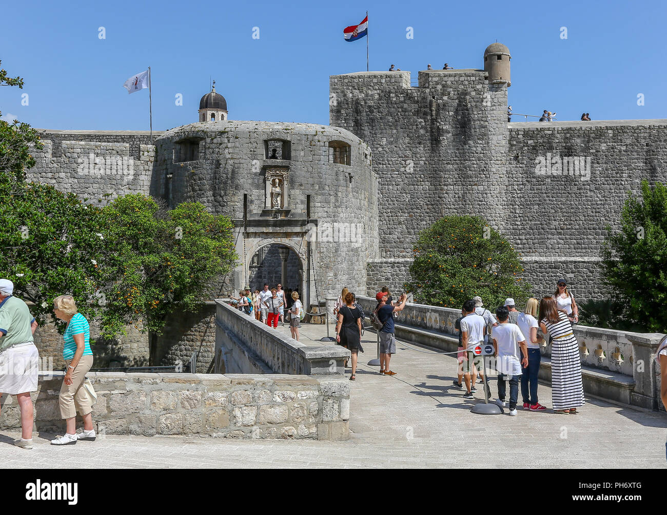 Le mura della città in corrispondenza della pila di gate e di un ponte che conduce al cancello di ingresso alla Città Vecchia, Dubrovnik, Croazia Foto Stock