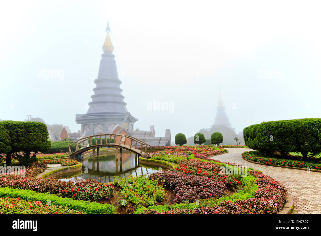 Giardino fiorito e stupa di mattina nebbia Foto Stock