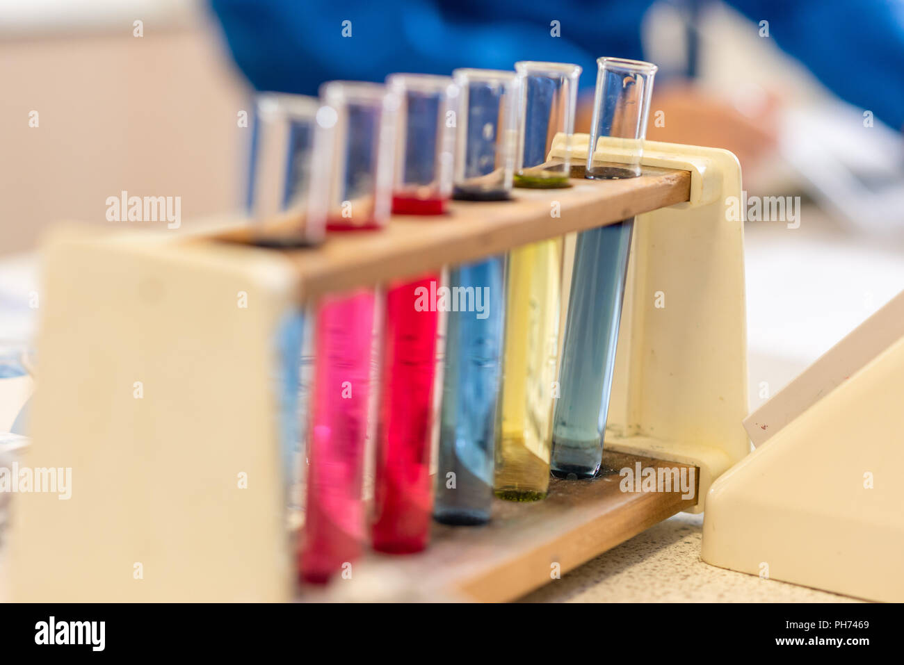 Colorati tubi di prova fotografato in un aula scolastica durante una lezione di scienze e di esperimento. Foto Stock