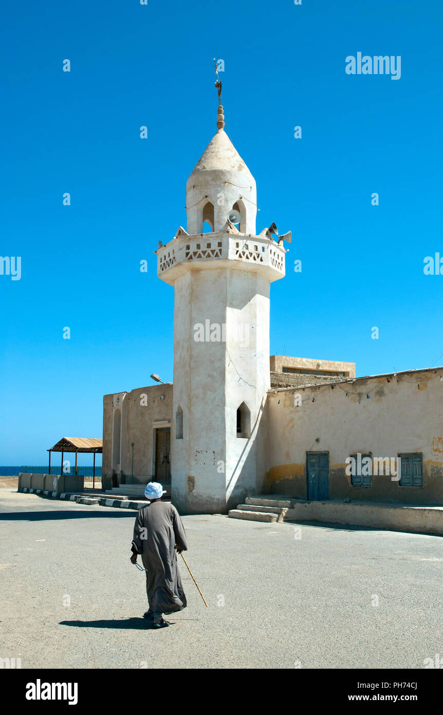 Uomo locale a piedi moschea Marsa Alam Town, Egitto Foto Stock