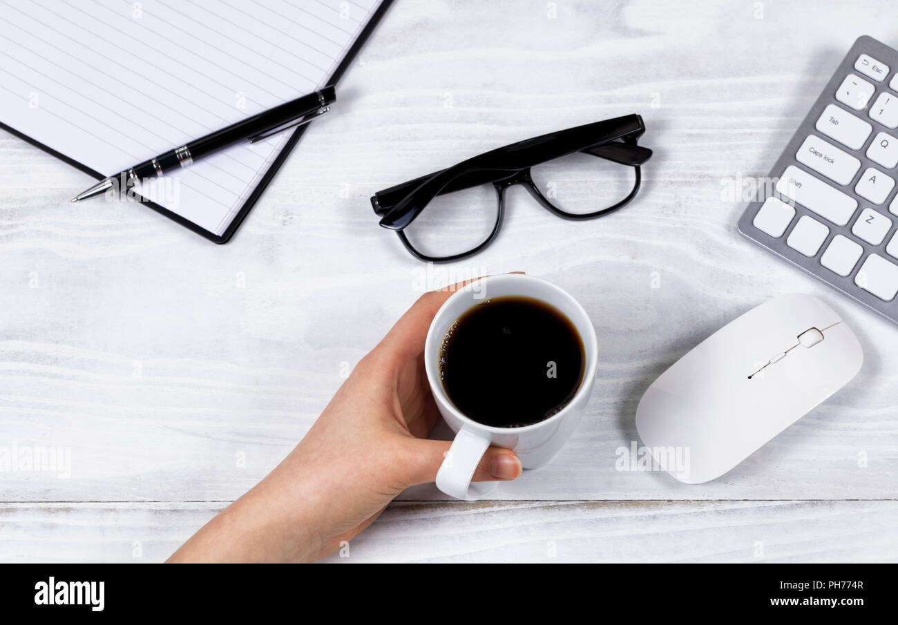 Femmina lato coppa di ritegno di caffè organizzata sul desktop bianco Foto Stock