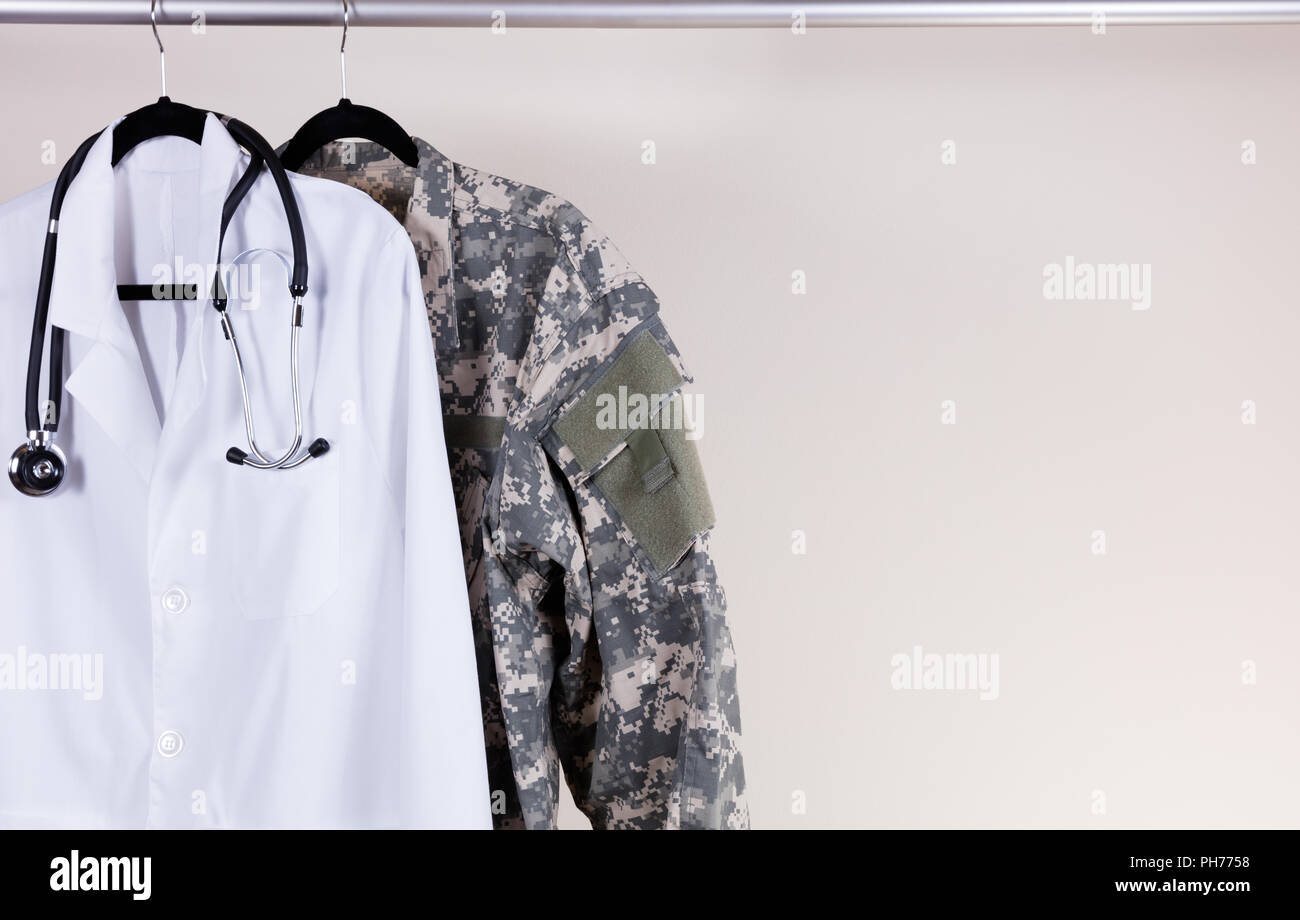 Medicale bianco la consultazione e il cappotto di uniforme militare sulla gruccia Foto Stock