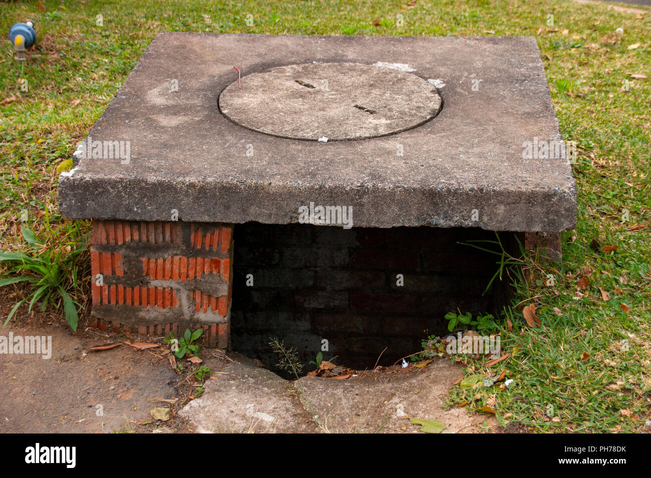 Una vista frontale di un drenaggio di acqua struttura su una strada principale Foto Stock