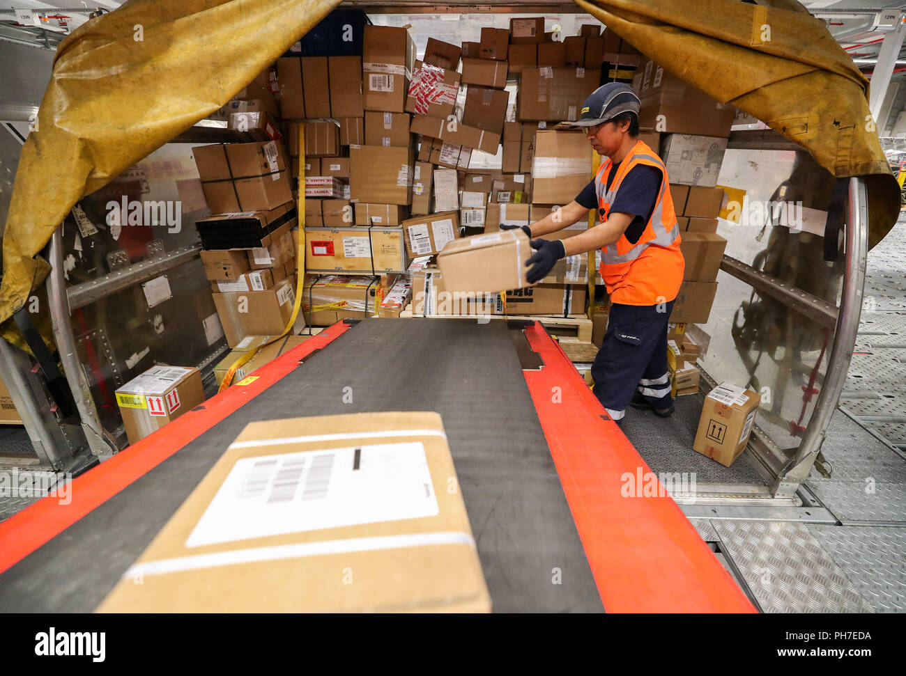 29.08.2018 Sassonia, Schkeuditz: DHL dipendenti aria di scarico i container per il trasporto merci di notte nel mozzo di DHL all'aeroporto di Leipzig/Halle. Il mozzo di DHL a Leipzig Airport entrò in funzione dieci anni fa. A quel tempo, 125.000 spedizioni sono state gestite al giorno in media, oggi è 350.000. Il mozzo di Lipsia ha sviluppato nel più grande all'interno del network DHL Express in dieci anni. Nel frattempo 5700 persone lavorano presso la posizione, 99 percento di essi dalla regione. In aggiunta ai cinque nuovi aeromobili, DHL è la pianificazione di un simulatore di volo per centro pilota di formazione e di addestramento. Foto: Jan Woitas/dpa-Zentr Foto Stock