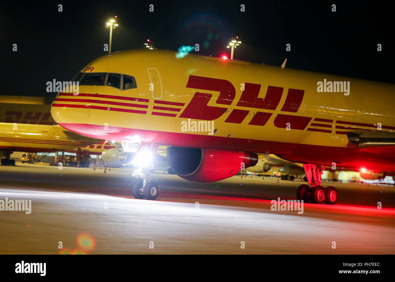 29.08.2018 Sassonia, Schkeuditz: DHL un velivolo da carico rotoli in pista all'aeroporto di Leipzig/Halle di notte. Il mozzo di DHL a Leipzig Airport entrò in funzione dieci anni fa. A quel tempo, 125.000 spedizioni sono state gestite al giorno in media, oggi è 350.000. Il mozzo di Lipsia ha sviluppato nel più grande all'interno del network DHL Express in dieci anni. Nel frattempo 5700 persone lavorano presso la posizione, 99 percento di essi dalla regione. In aggiunta ai cinque nuovi aeromobili, DHL è la pianificazione di un simulatore di volo per centro pilota di formazione e di addestramento. Foto: Jan Woitas/dpa-Zentralbild/dpa Foto Stock