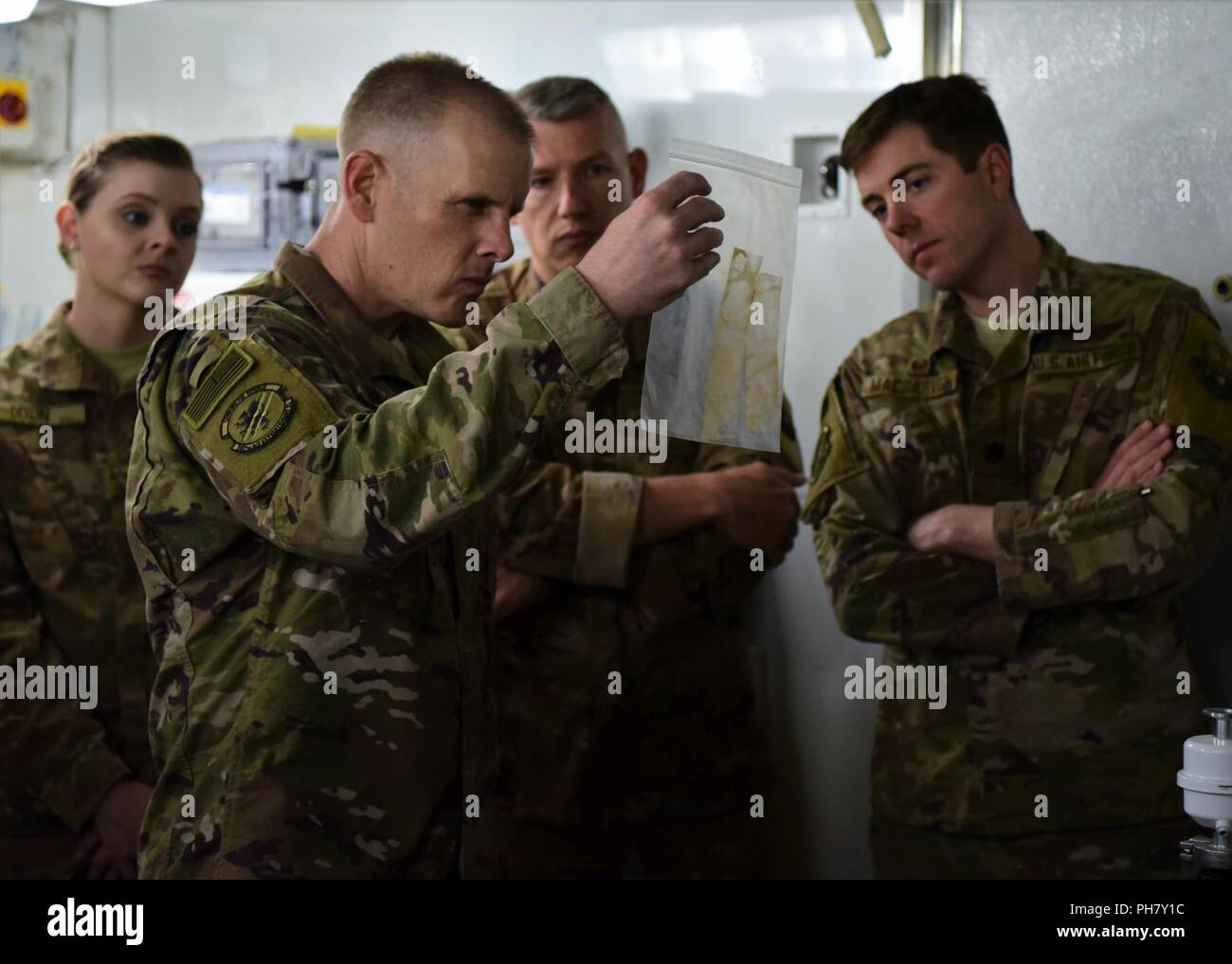 Senior Airman Paige Dixon, Chief Master Sgt. Christopher Walker, Senior Master Sgt. Brian Rohlman e il tenente Col. Mason MacGarvey, tutti parte dell'aria 387 Expeditionary Squadron, ispezionare il residuo di esplosione durante una visita al Campo di livello Arifjan-II laboratorio forense, 27 giugno 2018. La 387 AES fornisce supporto amministrativo per più di 410 Joint Expeditionary Task e singoli Augmentee aviatori, che abbracciano più di 100 Air Force codici speciali e sono attualmente implementate in avanti per 11 paesi. Foto Stock