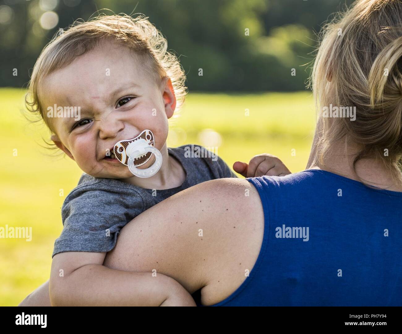 Luca Hofman sorrisi mentre nelle braccia della madre sua, Staff Sgt. Alicia Hofman, U.S. La riserva di esercito di soldati in precedenza con la 303Polizia Militare Società di Jackson, Michigan, durante un annuale "Happy viva giorno' picnic in Stockbridge, Michigan, 16 giugno 2018. I soldati della 303MP Azienda sopravvissuti a un attacco dei talebani sulla loro base mentre distribuito a Kandahar, Afghanistan, 19 giugno 2012. I soldati organizzare il picnic ogni anno per celebrare la vita e a mostrare che l unità nella fratellanza militare è più forte che i nemici che hanno attaccato loro. Dodici soldati dell'unità ricevuta la Purpl Foto Stock