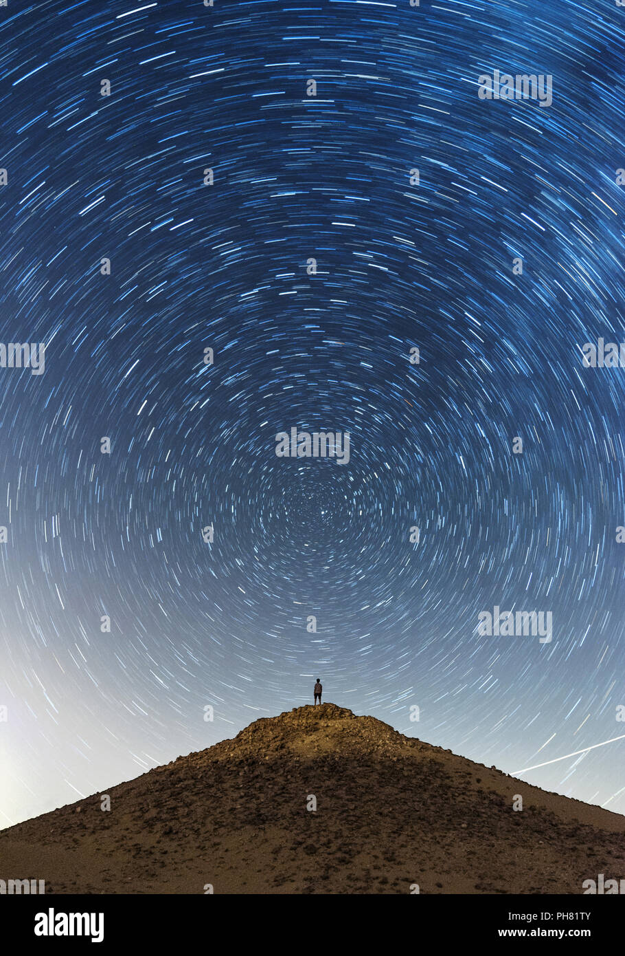 Paesaggio con startrails di un uomo su una montagna Foto Stock